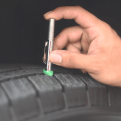 A hand pushes the PCL Tyre Tread Depth Gauge into the Groove of a tyre