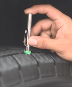 A hand pushes the PCL Tyre Tread Depth Gauge into the Groove of a tyre