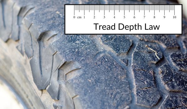 A balding tyre with a picture of a ruler in a text box which reads: tread depth law