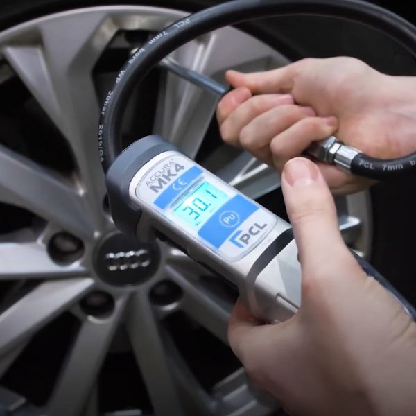 A tyre inflator powered by an air compressor which is hooked up to a car tyre.