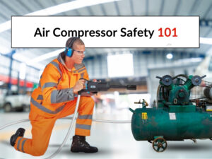 Air compressor safety in practice: A man dressed in hi-viz clothing kneeling on the floor with an air tool attached to his air hose. He is wearing ear muffs for protection.