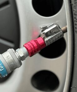 The silver and red closed tailpiece tyre connector from PCL attached to the wheel of a car.